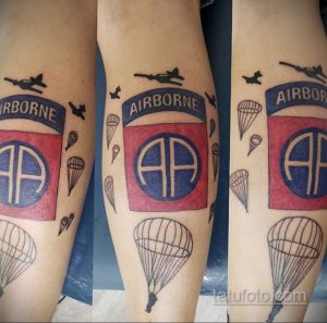 Фото татуировки с изображением парашютистов, самолета и надписи 'AIRBORNE' на руке. Цветная татуировка в стиле традиционный.