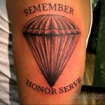 Фото тату на руке: стилизованный парашют с надписями 'REMEMBER' и 'HONOR SERVE'. Простой, но выразительный рисунок татуировки в черно-серых тонах.