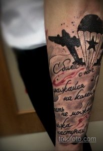 Фото татуировки на руке с изображением самолета, звезды и надписи на русском языке. Черно-серый рисунок с эффектом брызг краски.