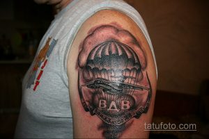 Фото тату с изображением парашюта и самолета на плече. Реалистичный черно-серый рисунок с высокой детализацией и надписью. Идеи для тату, посвященные ВДВ.