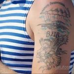 Фото старой, выцветшей татуировки на плече с изображением парашюта, орла и надписи 'ВДВ'. Рисунок выполнен в черно-серых тонах.
