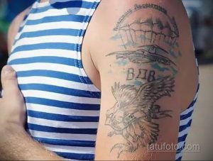 Фото старой, выцветшей татуировки на плече с изображением парашюта, орла и надписи 'ВДВ'. Рисунок выполнен в черно-серых тонах.