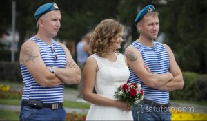 Фото тату на плече двух мужчин: татуировки военной тематики на фоне свадебной церемонии. Детализированный рисунок татуировки с символикой ВДВ.