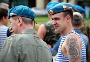 Фото тату на груди и плече мужчины: реалистичный портрет тигра, выполненный в черно-серых тонах. Детализированный рисунок татуировки с хищным зверем.