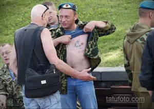 Фото тату на груди мужчины: ангел с мечом и щитом, выполненное в черно-белой гамме. Детализированный рисунок татуировки символизирует защиту и веру.