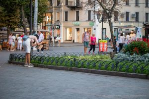 Фотография людей с татуировками на улице города. Видны татуировки на руках, ногах и других частях тела.