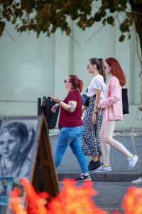 Фото тату: черно-белый рисунок льва на плече женщины. Детализированная проработка гривы, мощный и гордый вид, реалистичный стиль.