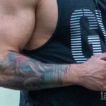 Фото тату: крупный план татуировки на руке мужчины. Видны темные контуры и детализированный рисунок, возможно, растительный орнамент.