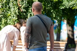 Крупный план татуировки на руке мужчины в стиле маори. Рисунок выполнен в черных тонах и охватывает большую часть плеча.