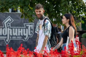 Крупный план рук мужчины с татуировками, идущего рядом с девушкой. Видны детали рисунков на коже.
