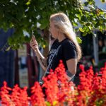 Фото тату на руке: небольшой рисунок черепа, обвитого розами. Детализированная татуировка в черно-серых тонах.