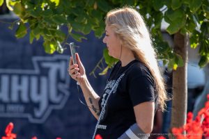 Фото тату на руке: небольшой рисунок черепа, обвитого розами. Детализированная татуировка в черно-серых тонах.