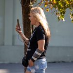 Фото тату на руке: небольшой рисунок черепа, обвитого розами. Детализированная татуировка в черно-серых тонах.