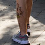 Смешные татуировки внизу ноги парня с рюкзаком – жирафом – мороженком и динозавром – tatufoto.com 5
