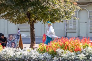 Фото уличного художника, рисующего портреты и татуировки. Яркие краски, творческая атмосфера, украинская символика.
