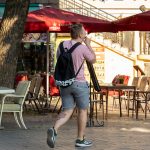 Фото тату на ноге у молодого человека, идущего по улице. Вид сзади, татуировка в стиле традиционной японской гравюры.