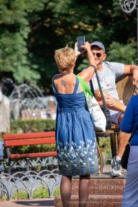 Фото тату на спине: небольшой рисунок волка, воющего на луну, выполненный в черном цвете. Женская татуировка на открытой спине.