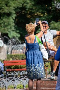Фото тату на спине: небольшой рисунок волка, воющего на луну, выполненный в черном цвете. Женская татуировка на открытой спине.
