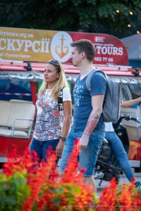 Фотография мужчины с уличной татуировкой на предплечье, выполненной в технике стрит-арт. Красные узоры и линии создают динамичный и привлекательный рисунок.