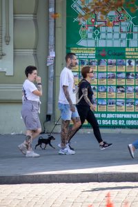 Фото татуировок на руках мужчины, выполненных в стиле графика. Мужчина гуляет с собакой.