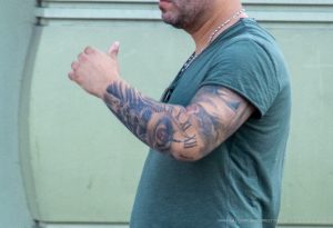 Фото тату на руке: рукав с изображением черепа, роз и римских цифр, выполненный в реалистичном стиле. Идеи для тату, мастер тату.
