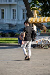 Фото тату на руке мужчины: рукав с изображением черепа, часов и цветов, выполненный в черно-серых тонах. Идеи для тату, мастер тату.