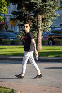 Фотография мужчины с татуировкой на руке в стиле графика. Татуировка изображает птицу, выполненную в черных тонах. Мужчина одет в черную футболку и солнцезащитные очки.