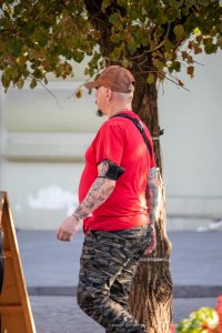 Фото тату на руке мужчины: детализированные рисунки в стиле олдскул и традиционные мотивы, покрывающие предплечье и плечо.