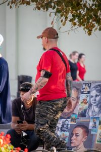 Фото мастера тату за работой. Мужчина с татуировками на руках, рисует эскизы и демонстрирует свои работы.