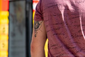 Фото тату на плече: изображение черепа, украшенного розой и геометрическими элементами. Черно-белая татуировка в стиле графика.
