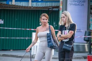 Фотография татуировки на плече женщины: изображение короны с розами. Видны детали рисунка и его расположение на теле.