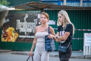 Фотография татуировки на плече женщины: изображение короны с розами. Видны детали рисунка и его расположение на теле.