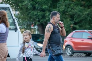 Фото тату на плече мужчины: якорь и православный крест, выполненные в черном цвете. Детализированный рисунок татуировки символизирует веру и надежду.