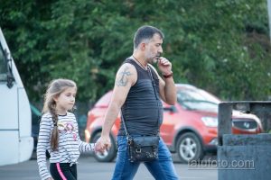 Фото тату на плече мужчины: якорь и православный крест, выполненные в черном цвете. Детализированный рисунок татуировки символизирует веру и надежду.