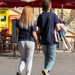 Фотография пары, держащейся за руки, с акцентом на татуировки на руке мужчины. Видны детализированные рисунки в стиле графика и реализм.
