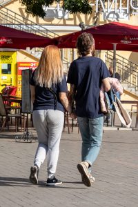 Фотография пары, держащейся за руки, с акцентом на татуировки на руке мужчины. Видны детализированные рисунки в стиле графика и реализм.