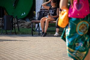 Фото девушки с татуировкой на руке, виднеющейся из-под рукава, с детализированным рисунком.