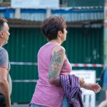 Фото тату павлина на плече женщины. Цветная татуировка с детально проработанными перьями и яркой цветовой гаммой. Идея для тату в стиле реализм.