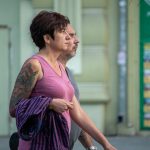 Фото татуировки на плече женщины: яркий рисунок с изображением мифологического существа, выполненный в технике олдскул с использованием ярких цветов.