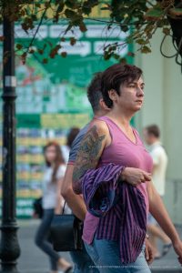 Фото татуировки на плече женщины: яркий рисунок с изображением мифологического существа, выполненный в технике олдскул с использованием ярких цветов.