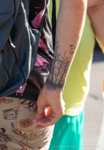 Фото тату дерева с птицами на предплечье. Черно-серый рисунок с детально проработанными ветвями и силуэтами птиц. Эскиз тату в стиле графика.