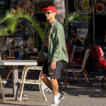 Фотография мужчины с татуировкой на ноге, стоящего на улице. Видна часть татуировки в японском стиле.