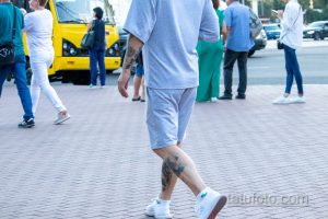 Фото тату на теле мужчины: рисунки на ноге и руке, выполненные в черном цвете. Видны детализированные узоры и символы.