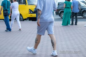 Фото тату на теле мужчины: рисунки на ноге и руке, выполненные в черном цвете. Видны детализированные узоры и символы.