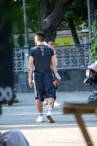 Фото тату на руке мужчины в спортивной одежде, татуировка с изображением животного, уличный стиль.
