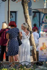 Фото тату скорпиона на спине женщины. Черно-белый рисунок, вид сбоку. Татуировка расположена между лопатками, на открытой коже.