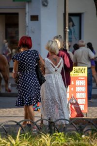 Фото тату скорпиона на спине женщины. Черно-белый рисунок, вид сзади. Татуировка расположена между лопатками, на открытой коже.