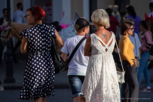 Фото тату скорпиона на спине женщины. Черно-белый рисунок, расположенный между лопатками. Детализированный эскиз татуировки, вид сзади.