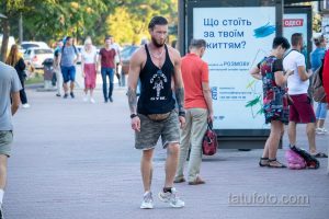 Фото тату: мужчина с татуировкой на руке, демонстрирующий свою спортивную форму. Татуировка выполнена в черных тонах и изображает воина.