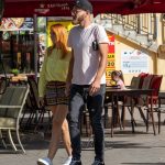 Фотография мужчины с татуировкой на предплечье, идущего по улице. Уличная татуировка, современный стиль, портретная фотография.